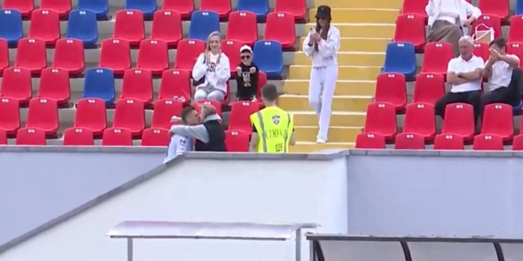 футболист празднует гол на стадионе с трибунами